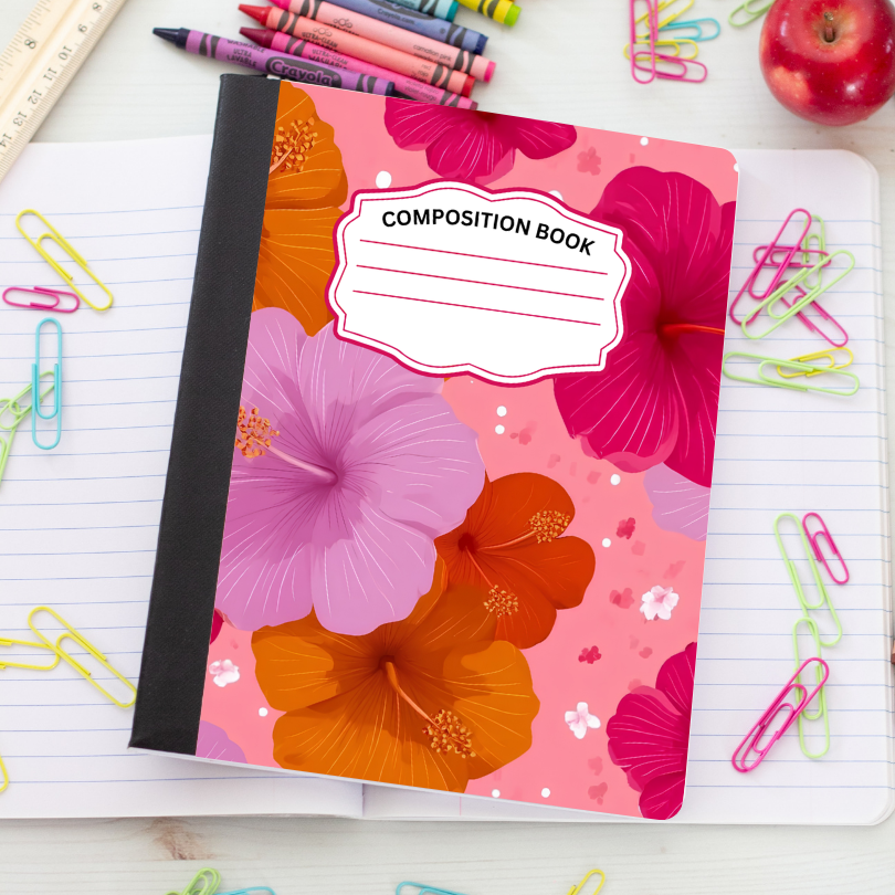 A floral composition notebook with pink, orange, and purple hibiscus flowers on the cover, placed on an open lined notebook with colorful paperclips around it.