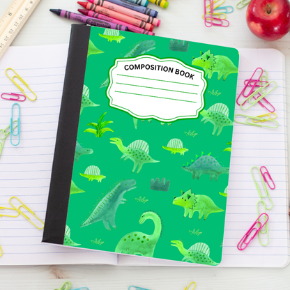 A green composition notebook with a dinosaur pattern, styled on an open lined notebook with colorful paperclips, crayons, and an apple.