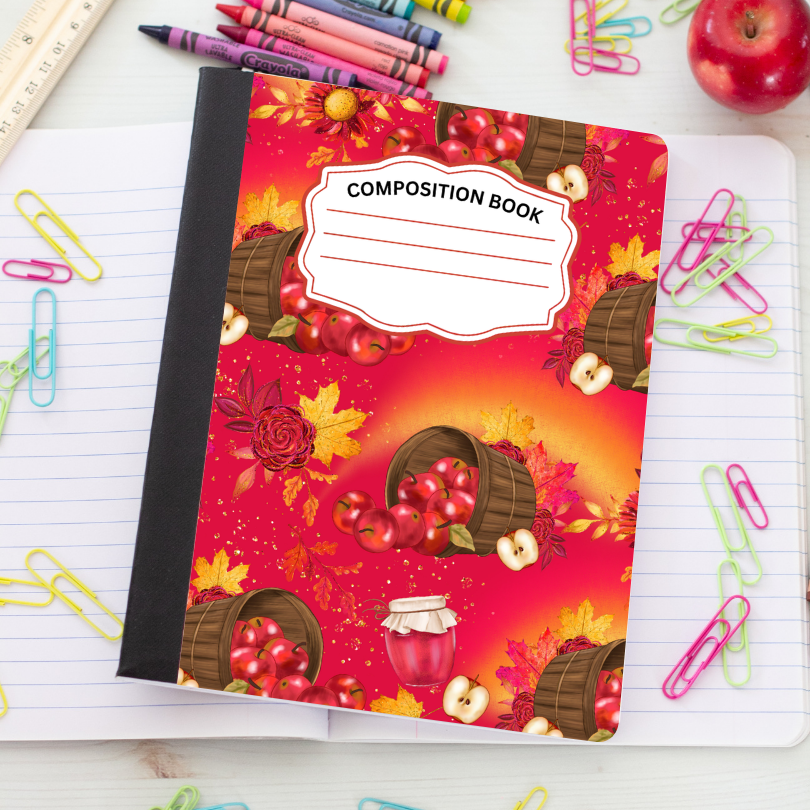 A composition book with a red autumn apple pattern lies open on a white desk, surrounded by colorful paperclips, crayons, a ruler, and an apple.