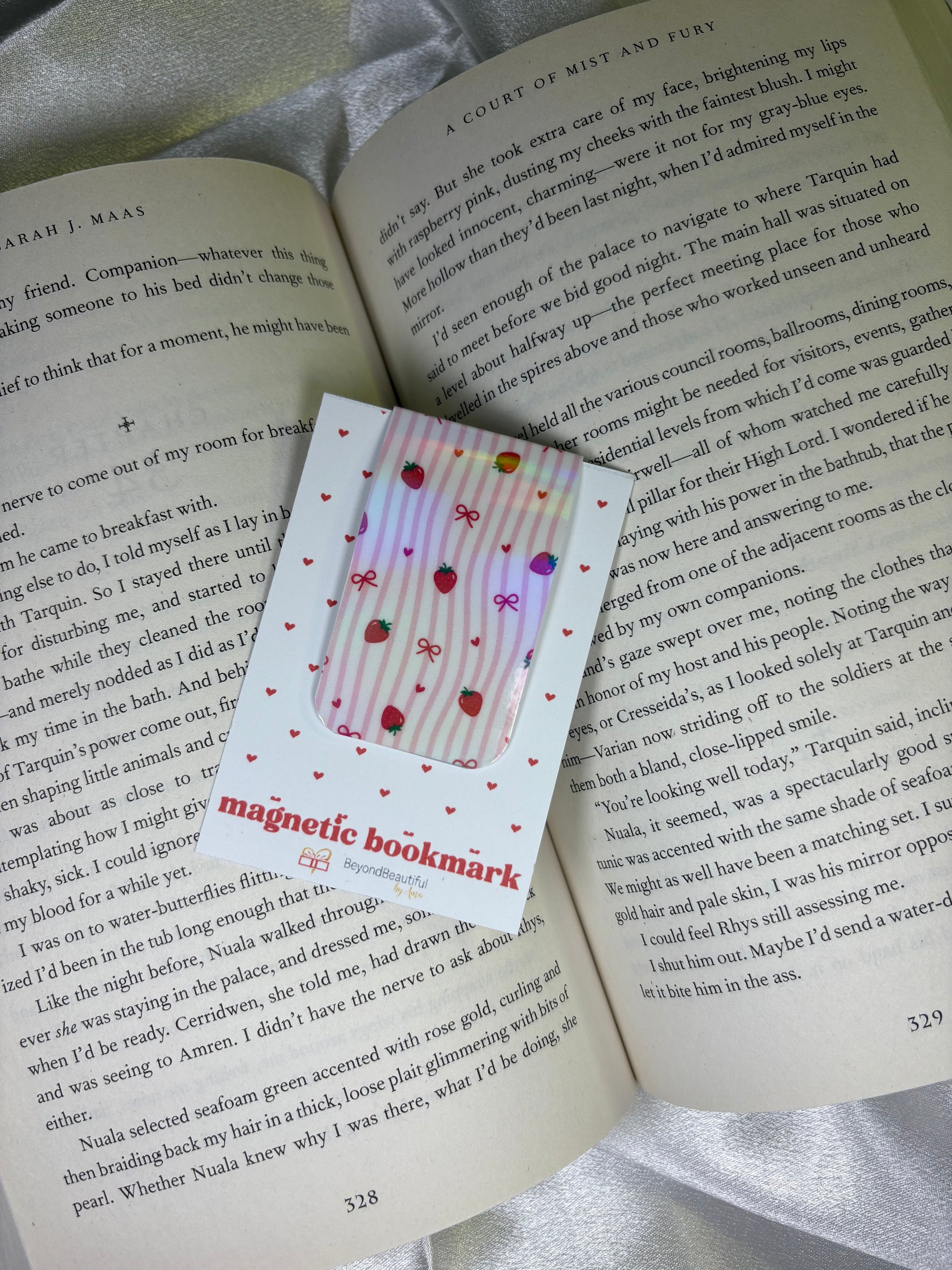 Magnetic bookmark with strawberry and bows design on an open book