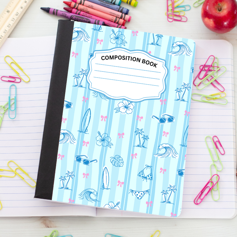 A composition book with a light blue and white striped cover featuring beach-themed illustrations, placed on an open lined notebook surrounded by colorful paperclips, pencils, a ruler, and an apple.